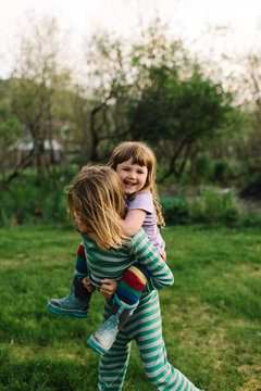 Young boy giving sister piggyback, outdoors