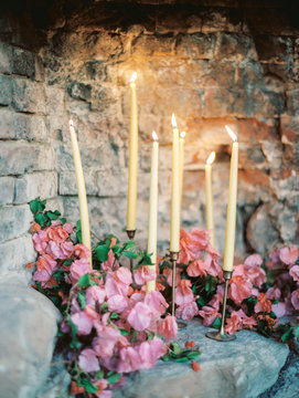 Flowers and candles against a wall 