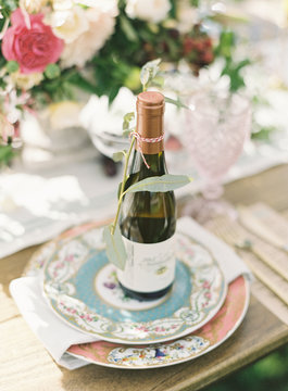 Bottle of wine on oranate plate at place setting