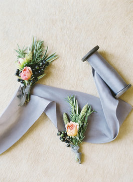 Flower Buttonholes and Roll of Ribbon at Wedding