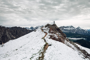 Person standing on top of snow covered mountain