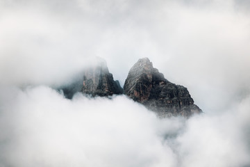 Clouds covering rocky mountain peak 