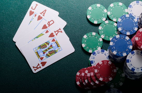 Casino chips and royal flush cards combination on the green table. Poker game concept