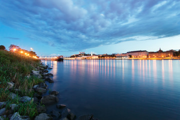 View across water of buildings illuminated night