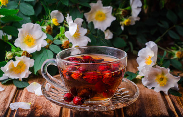 Healthy tea with a dogrose on a wooden board. Selective focus