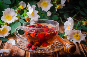 Healthy tea with a dogrose on a wooden board. Selective focus