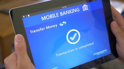 Transfering money founds with a mobile online banking application on a iPad tablet device.