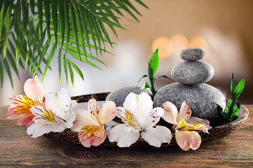 Composition with spa stones and alstroemeria on blurred background