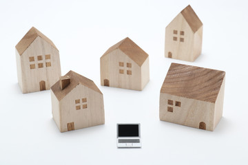 Laptop and houses.
Miniature houses and notebook PC on white background.
