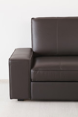Brown leather sofa against the wall