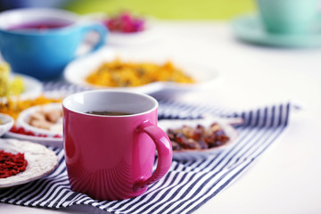 Cup of tea with aromatic dry tea on wooden background