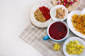 Cup of tea with aromatic dry tea on wooden background