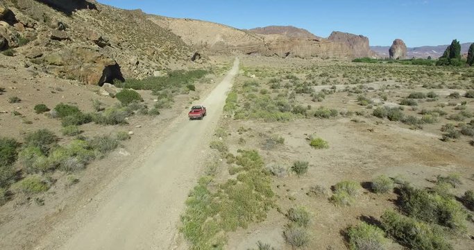 Aerial scene of car traveling on dirt road a dry, rocky, landscape. Monumental scenery. Start far from car, ends closer. Canyon of Piedra Parada, Chubut, Patagonia Argentina. Hiking place. 