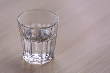 Glass of pure water on light wooden table