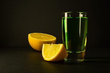 Absinthe and lime on black background