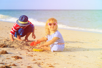 kids play with sand on summer beach