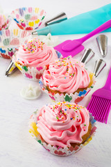 Pink cupcakes  and kitchen utensils, vertical