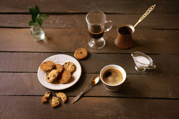 Cup of coffee with cookies on wooden table