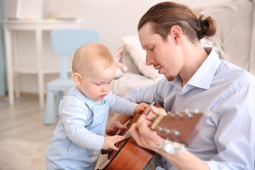 Father playing guitar to his son