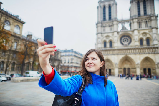 Beautiful young tourist in Paris, making funny selfie