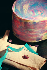 Colorful frosted cake on black background