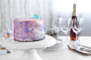 Tasty color cake with macaroon on table