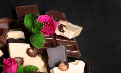 Chocolate pieces with rose on black background