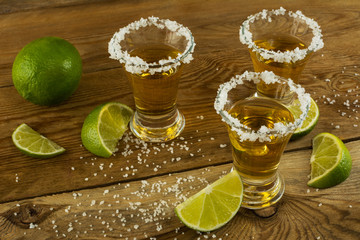 Gold tequila shots on the rustic wooden table