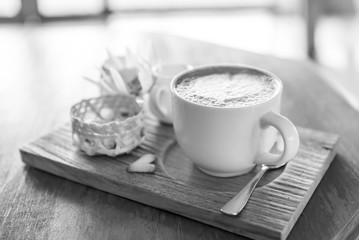 black and white of A cappuccino and some biscuits on the table