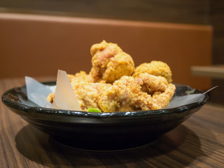 Fresh fried chicken on black plate set on wood table