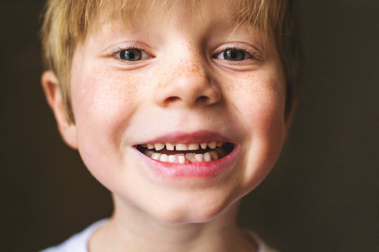 Close-up portrait of a boy with missing tooth