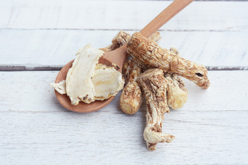 dang gui, angelica sinensis, dang gui ginseng on wooden background, traditional chinese herbal medicine.