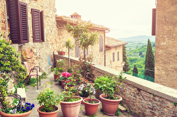 Fototapeta na wymiar Terrace with flowers in an ancient italian house.
