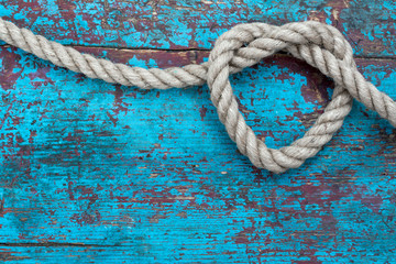Heart from rope on blue background