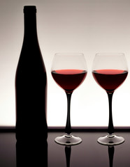 Silhouette of a bottle of wine with  two glasses with red wine