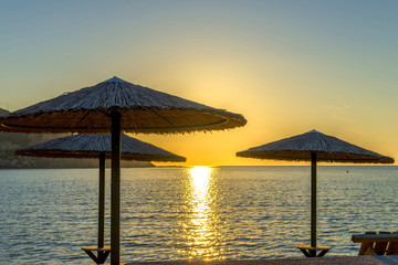 Magnificent sunset through umbrellas at the beach. Summer day in