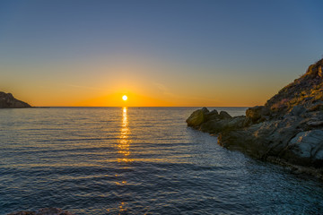 Fototapeta premium Amazing sunset in the sea. The sun falls into the Aegean sea cre