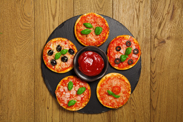 Mix of mini pizzas on a stone try