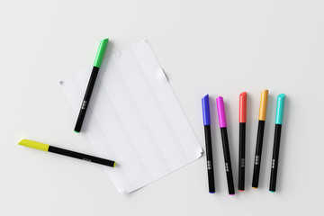 Colorful pens with sheet of paper