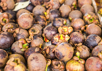 Fresh mangosteen for sale at an outdoor market.