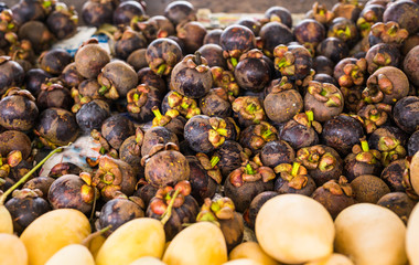 Fresh mangosteen for sale at an outdoor market.