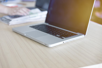 laptop computer on wooden table with newspaper