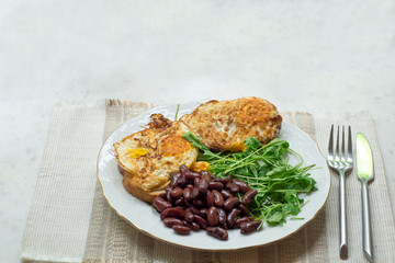 Omelette with backed beans on a white plate