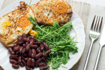 Omelette with backed beans on a white plate