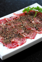 Premium raw japanese kobe beef sliced on plate with black pepper