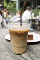 iced latte coffee with brownie on wooden table