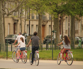 Familia paseando en bicicleta por un parque urbano