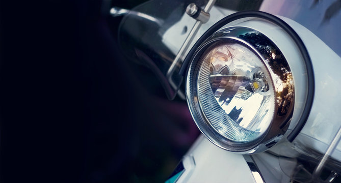 Colorful headlight of scooter on dark background
