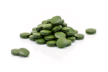 green spirulina chlorella algae seaweed pills close up on white