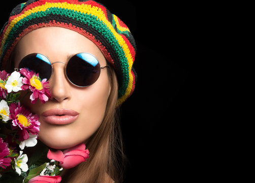 Pretty hippie girl in sunglasses with flowers